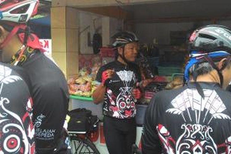 Para peserta Jelajah Sepeda Kompas sedang menikmati Dodol Kandangan di pinggir Jalan Simpang Negara, Kandangan, Kalimantan Selatan, Selasa (5/5/2015).