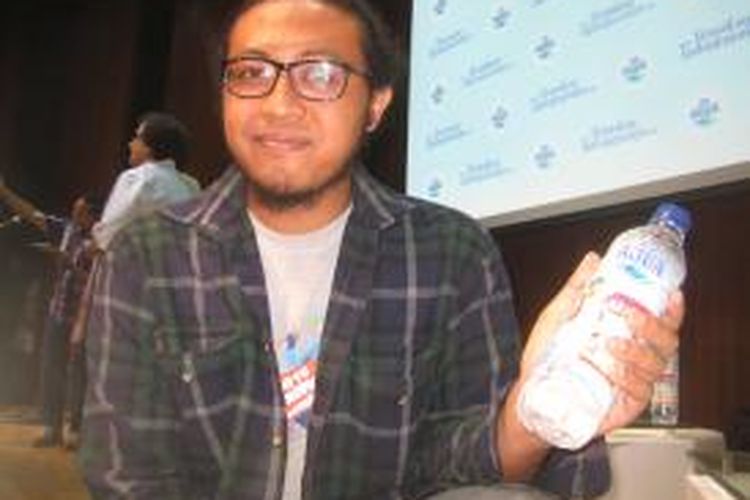 Eko Nurcahyo memegang botol edisi khusus Aquo 600 mililiter berlabel karyanya pada Kamis (28/11/2013). Botol dengan desain karyanya itu akan dirilis ke publik mulai 4 Desember 2013. Eko Nurcahyo adalah pemenang kategori desain program Danone Aqua 