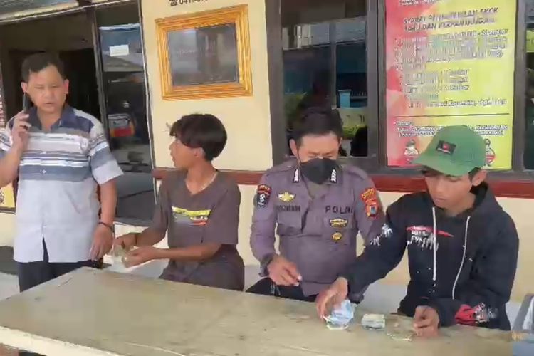 Dua 'pak ogah' yang diamankan polisi menunjukkan sejumlah barang bukti uang tunai hasil modus mengatur lalu lintas di Jalan Borong Raya Timur, Kecamatan Manggala, Kota Makassar, Sulsel, Rabu (14/6/2023)