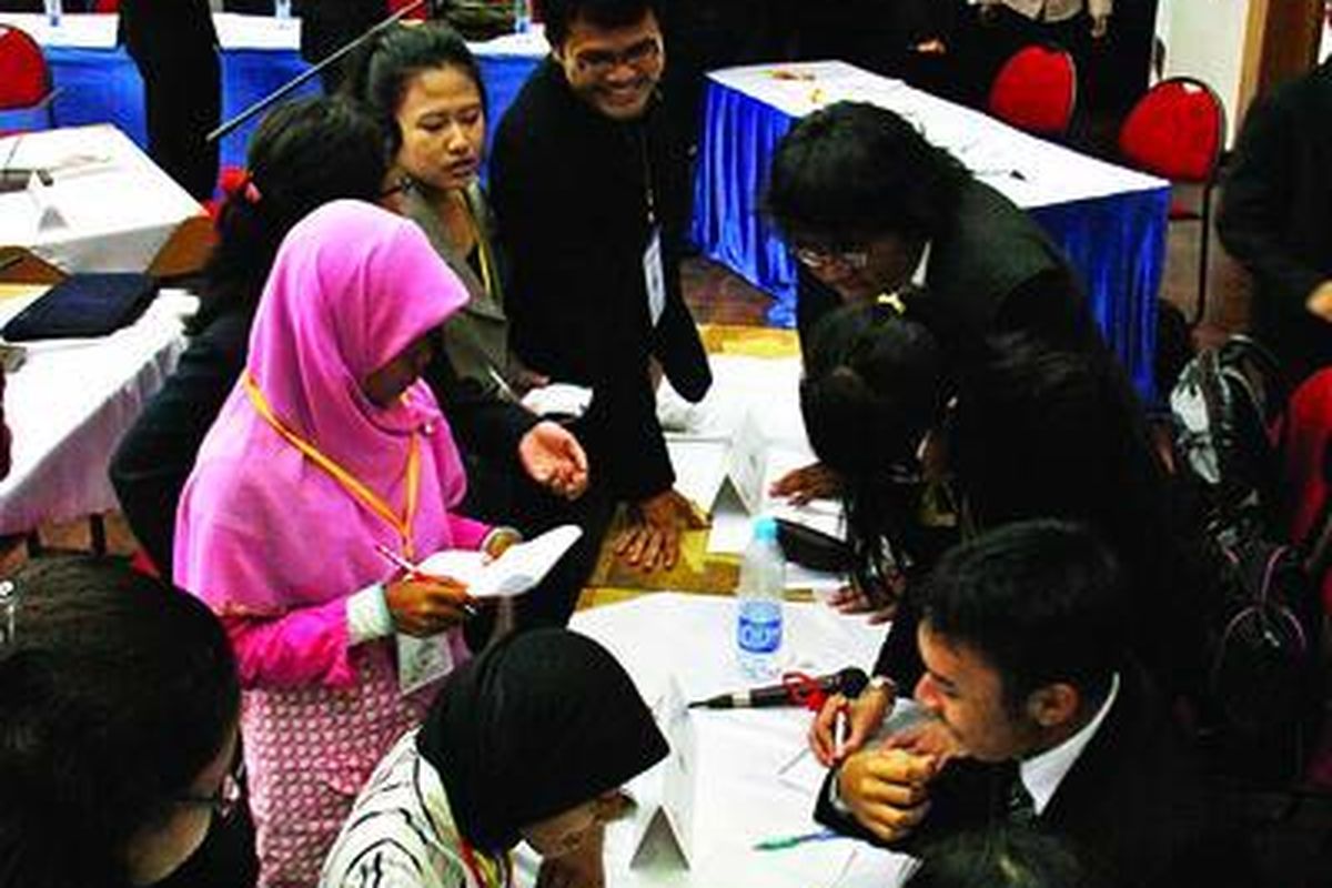 Delegasi IndonesiaMUN berdiskusi dalam simulasi sidang PBB.