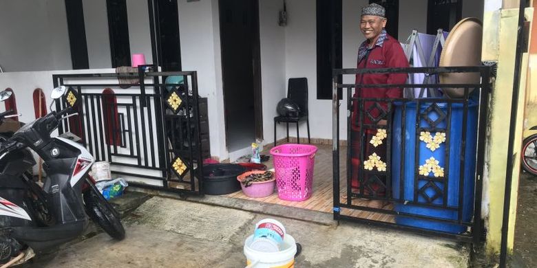 Warga di Perumahan Bukit Raya, Batam,  Provinsi Kepri, Muchtar sedang mencuci baju di halaman rumahnya menggunakan air hujan karena suplai air bersih tidak mengalir selama empat hari di perumahan itu, Senin (23/1/2023).