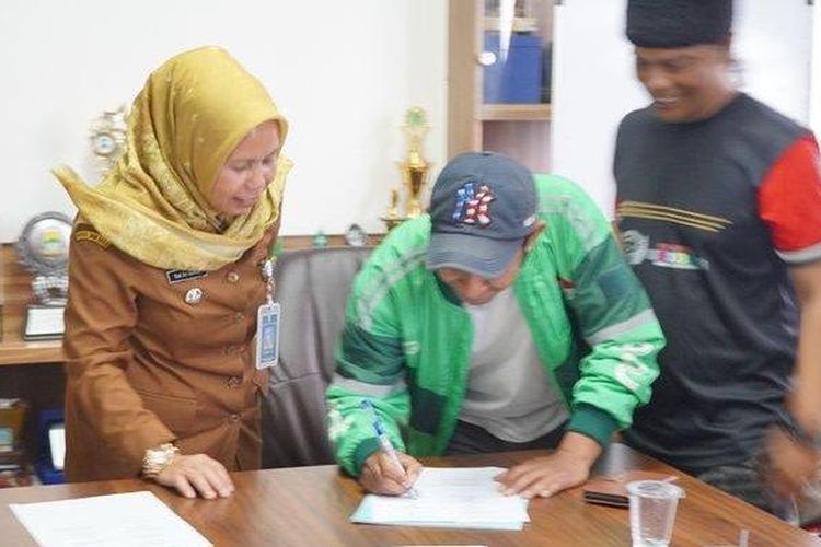 Camat Mandalajati, Yati Sri Sumiati, menyaksikan penandatangan keputusan bersama menyelesaikan masalah ojol-opang di Pasir Impun, Mandalajati, Bandung, Selasa (10/9/2024) malam. 

