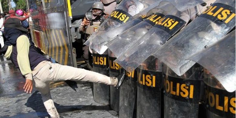 Pengunjuk rasa menendang barikade personel Polda Sulawesi Tenggara saat aksi menuntut penuntasan kasus kematian mahasiswa di depan Polda Sulawesi Tenggara, Kendari, Selasa (22/10). 