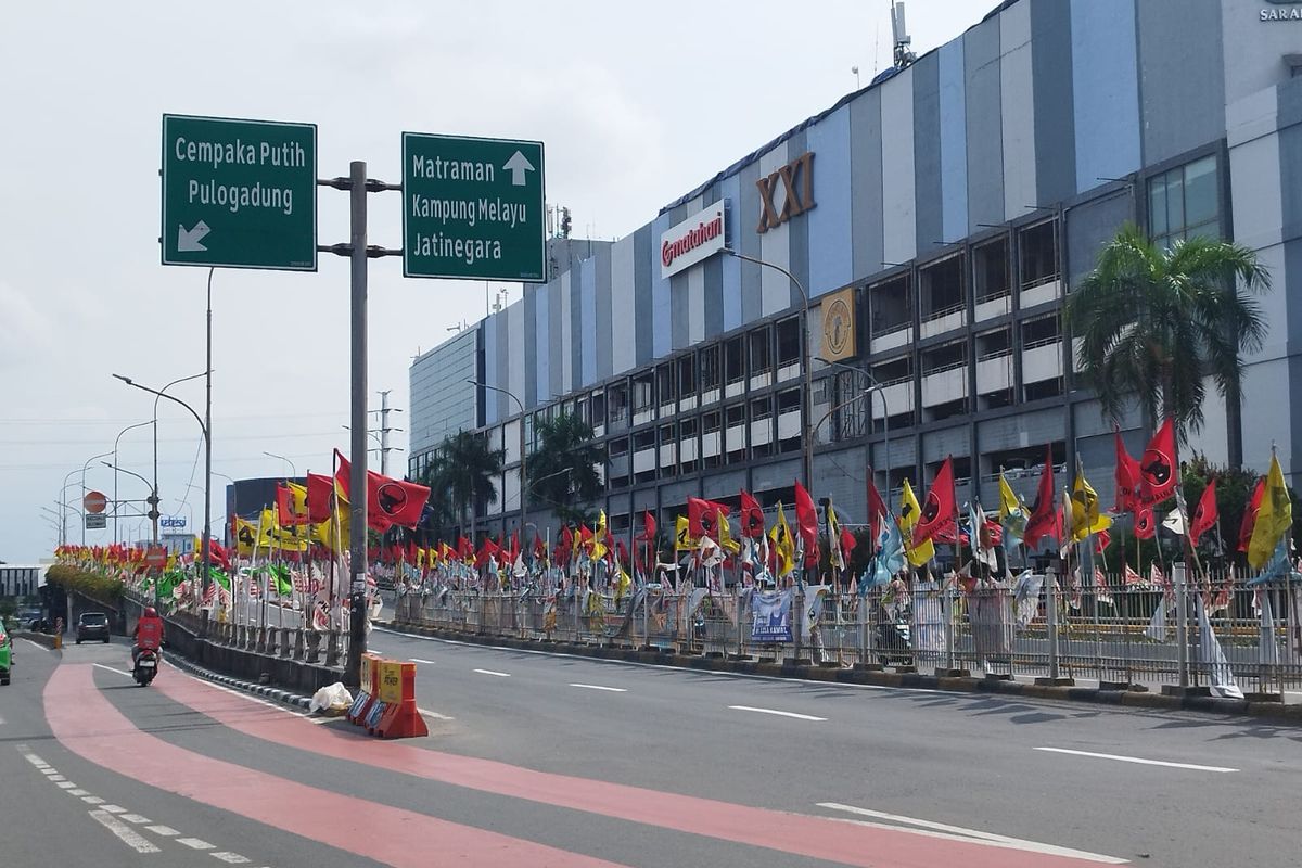 Ratusan bendera partai politik (parpol) berkibar di pagar pembatas Flyover Senen, Jakarta Pusat, Minggu (14/1/2024).