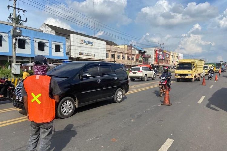 Petugas mengatur arus lalu lintas karena terjadi penyempitan jalan disebabkan adanya perbaikan jalan di perbatasan Kota Palembang, Sumatera Selatan. 
