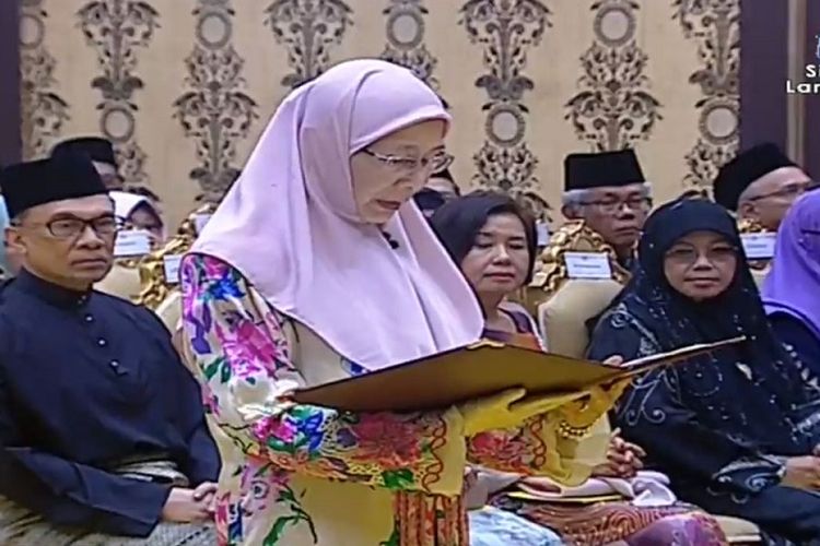 Wan Azizah Wan Ismail saat pelantikannya sebagai Wakil Perdana Menteri Malaysia di Istana Negara, Kuala Lumpur, Senin (21/5/2018). Sang suami, Anwar Ibrahim (duduk paling kiri) melihat pelantikan istrinya.