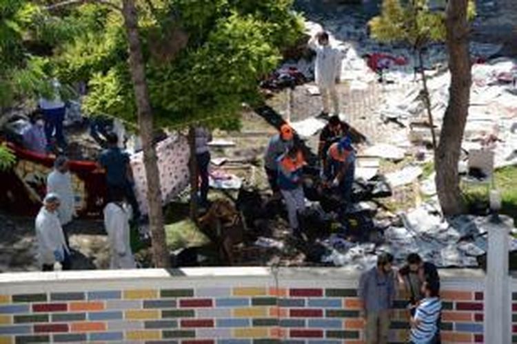 Petugas mengumpulkan jenasah korban setelah sebuah ledakan terjadi di kota Suruc, Turki yang terletak tak jauh dari perbatasan dengan Suriah, Senin (20/7/2015). 31 orang tewas dan ratusan terluka dalam peristiwa bom bunuh diri yang diduga dengan terkait Negara Islam Irak dan Suriah (ISIS).