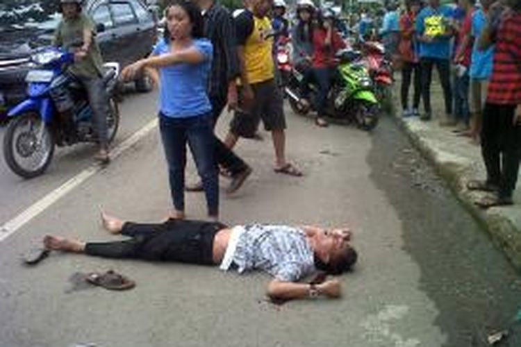 Irfan (21) tengah terkapar di jalan raya dengan luka pada bagian kepala sebelum akhirnya di evakuasi ke Rumah Sakit Umum Daerah (RSUD) Tenriawaru, Kabupaten Bone, Sulawesi Selatan. Senin, (23/12/2013).