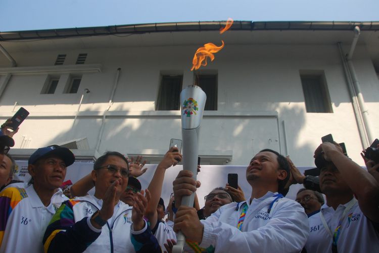 Menteri Komunikasi dan Informatika Rudiantara bersama Wali Kota Bogor Bima Arya Sugiarto memegang obor Asian Games dalam torch relay Asian Games di Kota Bogor, Selasa (14/8/2018).