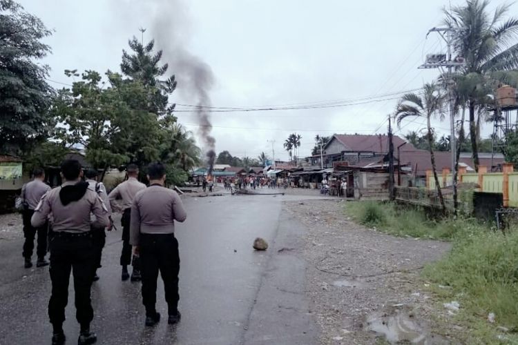 Polisi ketika berupaya bernegosiasi dengan warga agar membuka blokade jalan.