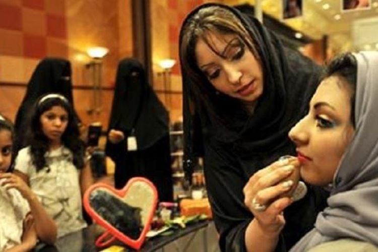 Seorang wanita Arab Saudi merias wajah seorang wanita lainnya di sebuah pameran kosmetik di Jeddah. (Foto: Dokumentasi)