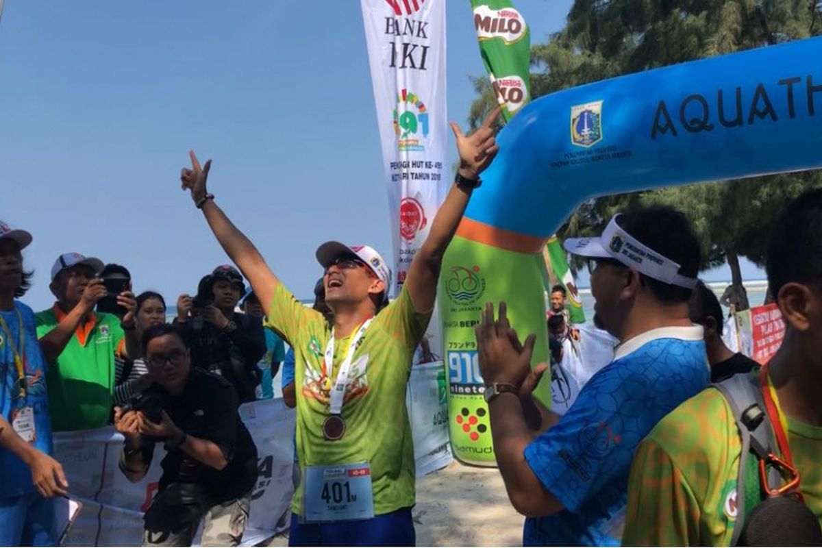 Wakil Gubernur DKI Jakarta Sandiaga Uno saat tiba di garis finish dalam perlombaan Tidung Aquathlon, Minggu (6/5/2018). 