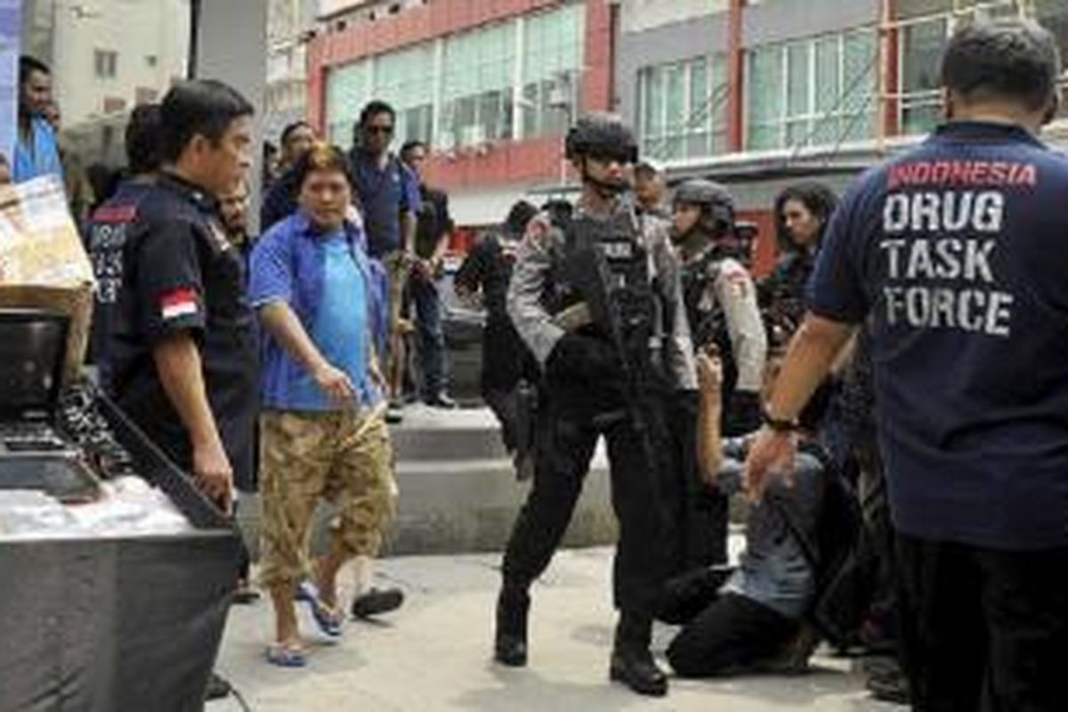 Terpidana mati kasus narkoba yang ditahan di Nusakambangan, Freddy Budiman (baju dan kaus biru), dihadirkan dalam rilis pengungkapan pabrik narkoba oleh Direktorat Tindak Pidana Narkoba Polri di ruko Mutiara Taman Palem, Cengkareng, Jakarta Barat, Selasa (14/4). Pabrik narkoba yang memproduksi ekstasi tersebut merupakan jaringan pengedar narkoba yang diduga dikendalikan oleh terpidana mati Freddy Budiman. Jaringan tersebut juga mengedarkan narkoba jenis baru, CC4, yang mempunyai bentuk seperti lembaran prangko. 