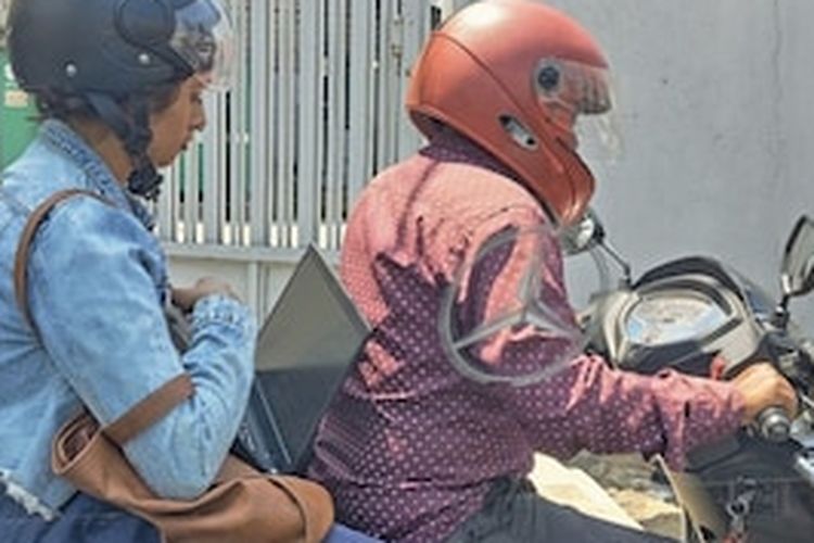 Wanita di Bengaluru, India terlihat mengeluarkan laptop dan bekerja di tengah kemacetan.