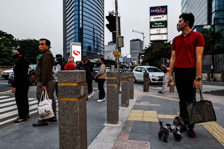 Sejumlah pekerja menggunakan masker berjalan kaki setelah meninggalkan perkantorannya di Jakarta, Rabu (29/7/2020). Klaster perkantoran penularan Covid-19 di Jakarta kini menjadi sorotan. Data resmi hingga Selasa (28/7/2020) kemarin, ada 440 karyawan di 68 perkantoran di Ibu Kota yang terinfeksi virus corona.