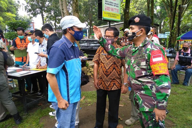 Wakil Ketua Operasi Satgas Covid-19, Kol. Inf. Azhar Mulyadi menepuk pundak ES yang sudah mengganti bajunya saat ditemui di Hairos Water Park. Sebelumnya ES mengenakan kemeja putih dengan tulisan Bobby Lovers di dada sebelah kiri.