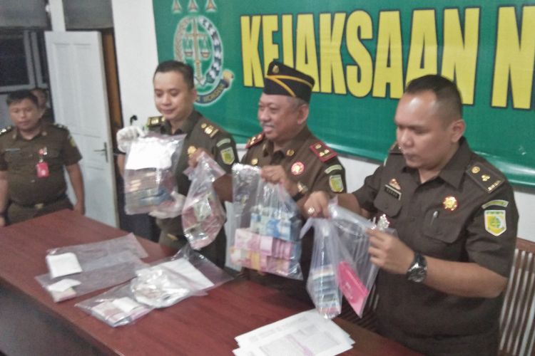 Pihak Kejaksaan Negeri Gresik saat memamerkan sejumlah barang bukti yang diamankan dari OTT di BPPKAD Gresik.