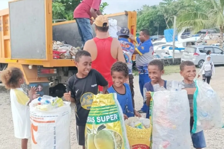 Anak-anak orang asli Papua sedang mengumpulkan limbah sampah rumah tangga untuk dipilah jenis sampah guna dijual kepada Bank Sampah ARB binaan Dinas Lingkungan Hidup Biak.