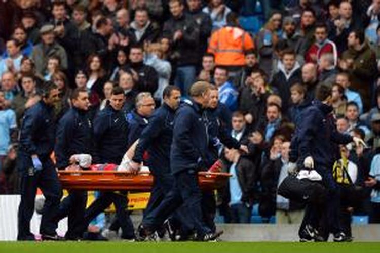 Bek Arsenal asal Perancis, Laurent Koscielny, ditandu keluar karena cedera lutut saat timnya tandang ke Etihad Stadium untuk melawan Manchester City dalam laga Premier League, Sabtu (14/12/2013). Arsenal kalah 3-6.