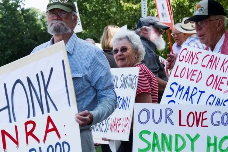 Sejumlah orang yang menolak hak kepemilikan senjata api berunjuk rasa di kantor NRA di Fairfax, Virginia.

