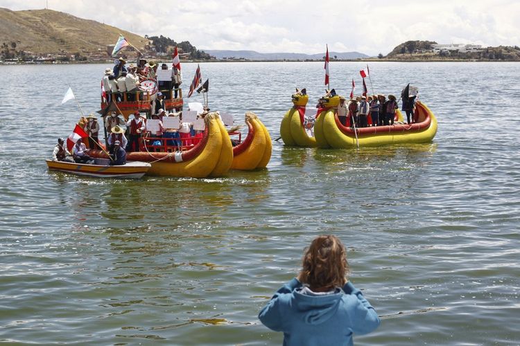 Warga pulau Uros dan Taquile di Danau Titicaca, yang berbatasan dengan Bolivia, tiba di kota Puno, Peru, untuk ikut serta dalam aksi protes menentang pemerintahan Dina Bolartue yang menuntut pengunduran diri dan penutupan Kongres pada 24 Januari 2023. Danau itu kini dilaporkan mengering.