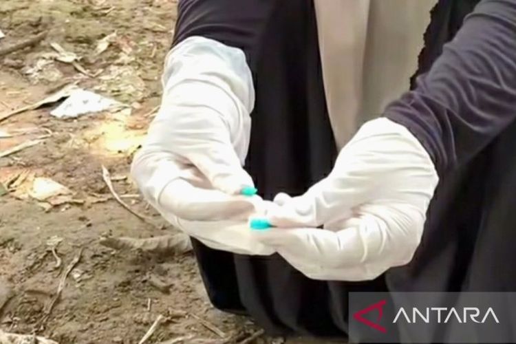 Petugas menunjukkan jarum suntik di antara tumpukan limbah medis yang ditemukan di area pemukiman warga di Desa Karangligar, Kecamatan Telukjambe Barat, Karawang, Kamis (10/4/2025). 