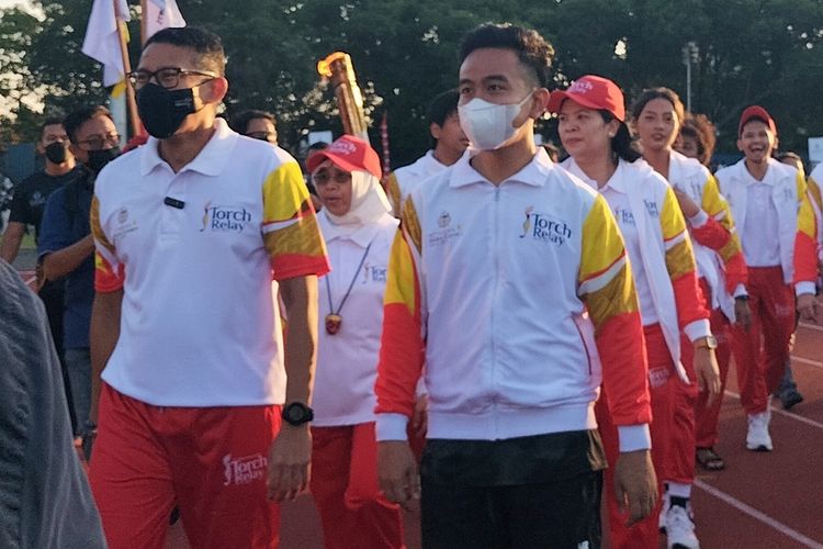 Menteri Pariwisata dan Ekonomi Kreatif (Menparekraf) Sandiaga Uno dan Wali Kota Solo Gibran Rakabuming Raka, saat ikuti torch relay atau pawai obor ASEAN Para Games 2022 di Kota Solo, Jawa Tengah, Minggu (24/7/2022).