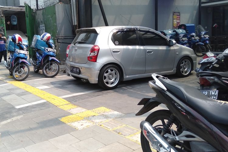 Mobil dan sepeda motor parkir di trotoar Jalan Kemang Raya, Mampang, Jakarta Selatan, Jumat (23/8/2019). Pejalan kaki pun terganggu ketika berjalan di trotoar tersebut.