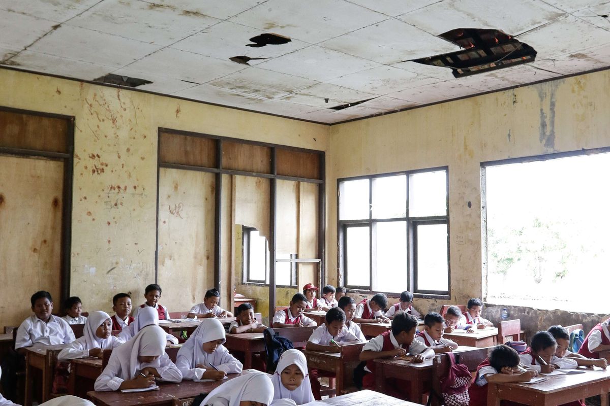 Murid SD Negeri Samudrajaya 04, Kecamatan Tarumajaya, Kabupaten Bekasi belajar di ruang kelas yang rusak, Senin (20/1/2020). Kondisi sekolah yang rusak sejak 2014 ini membuat proses belajar mengajar tidak nyaman.