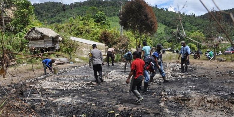 Warga Desa Lemban Tongoa bersama polisi membersihkan sisa-sisa puing bangunan milik korban yang dibakar oleh kelompok Mujahidin Indonesia Timur pimpinan Ali Kalora.