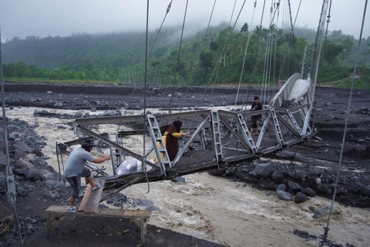 Jembatan Gantung Kaliregoyo di Dusun Sumberwuluh, Candipuro, Lumajang, Jawa Timur, diterang banjir lahar hujan.