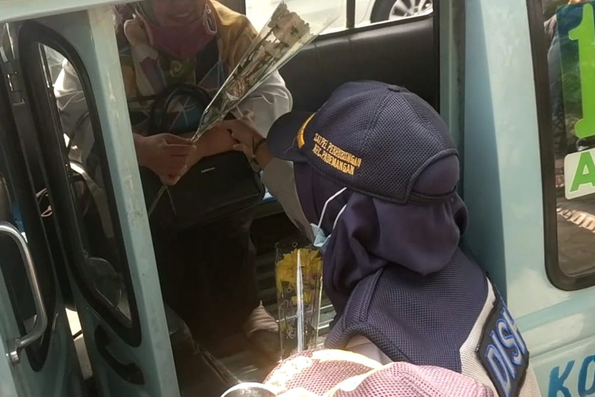 Sudinhub Jakarta Utara bagi-bagi bunga untuk pengguna transportasi umum di Jalan Gunung Sahari, Senin (9/8/2019)