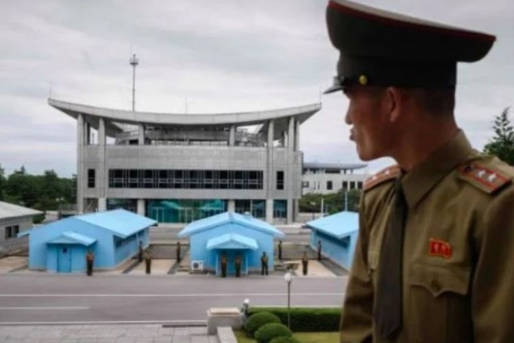 Anggota Tentara Rakyat Korea berdiri di sisi Korea Utara dan menghadap ke wilayah Korea Selatan di desa perbatasan, Panmunjom.