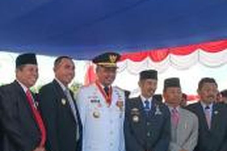 Gubernur Sultra Nur Alam memakai kostum putih diapit para bupati dalam sebuah acara