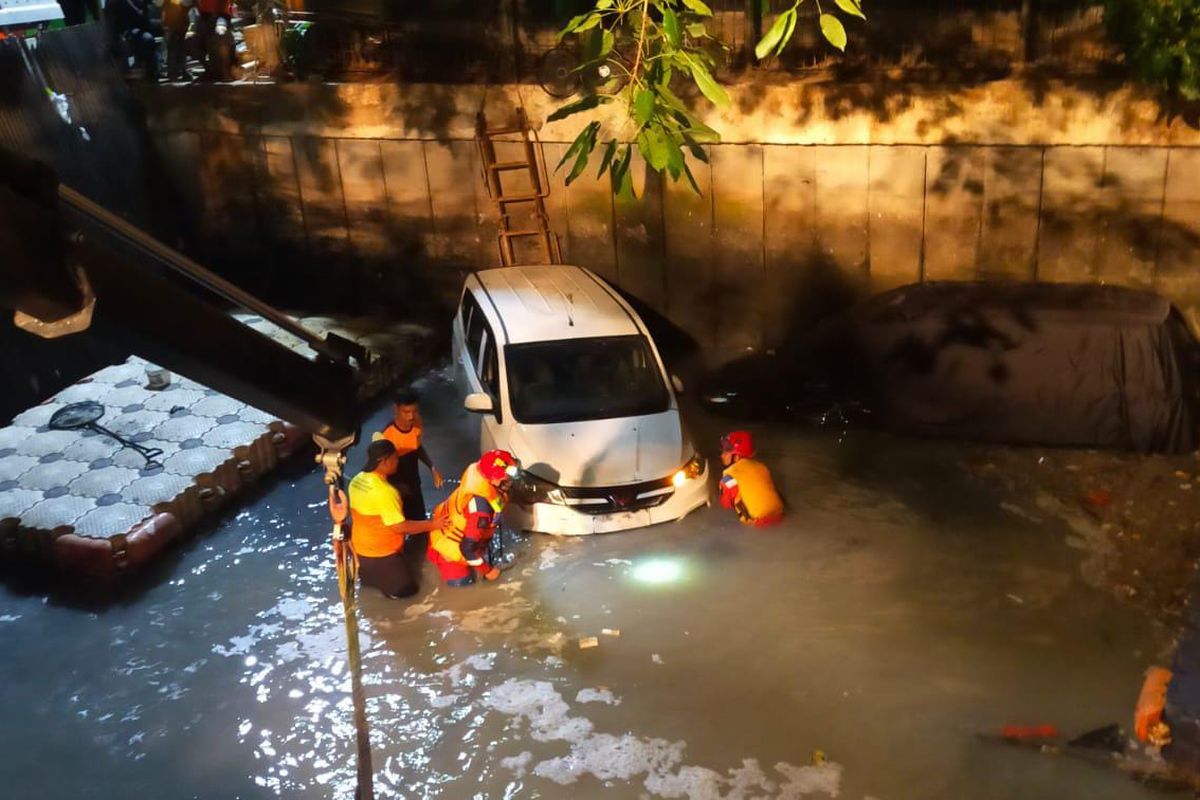 Mobil terjun ke saluran air di Jalan Raya Tomang, Jakarta Barat. 