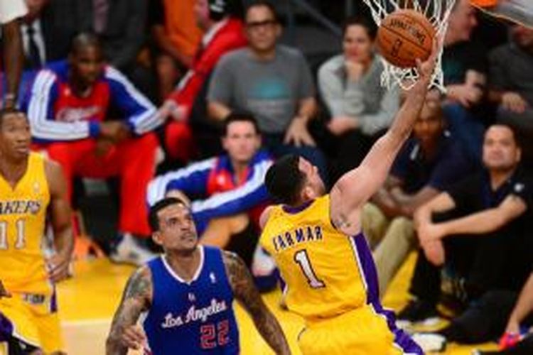 Pebasket Los Angeles Lakers, Jordan Farmar (1) berusaha memasukkan bola sambil dilihat oleh pemain Los Angeles Clippers, Matt Barnes. Kedua tim bertemu  dalam laga perdana musim ini di Los Angeles, Selasa (29/10/2013).