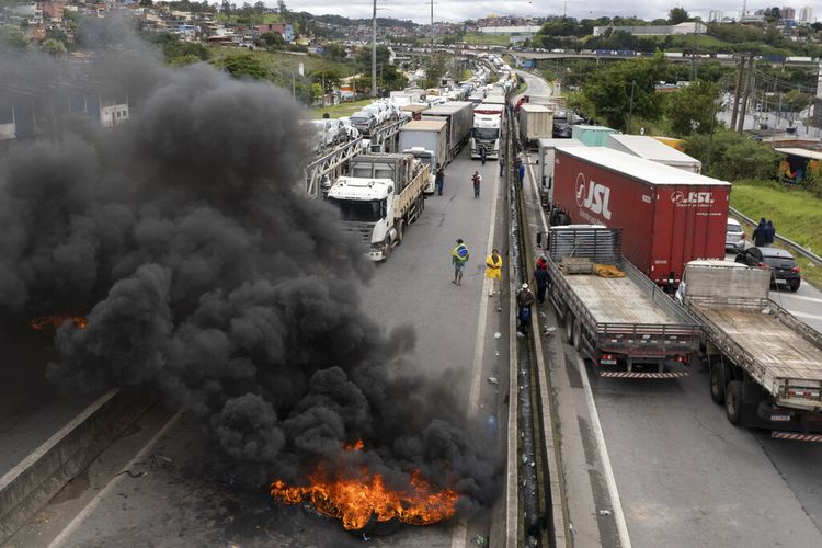 Para sopir truk pendukung Presiden Brasil Jair Bolsonaro memblokade jalan raya untuk memprotes kekalahannya dalam pemilihan putaran kedua dari mantan Presiden Luiz Inacio Lula da Silva di Embu das Artes di pinggiran Sao Paulo, Brasil, Selasa (1/11/2022).