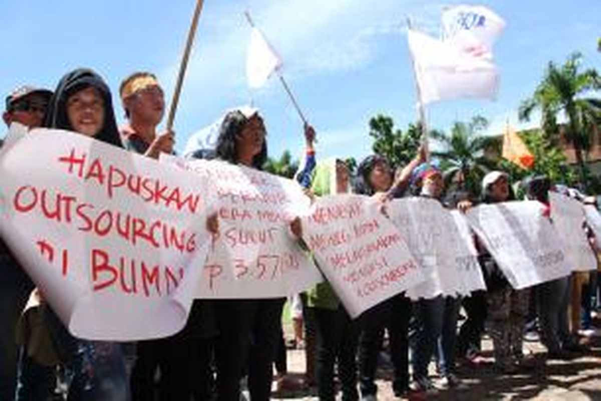 Sebagian buruh di Manado yang berdemo membawa poster yang bertuliskan tuntutan mereka.