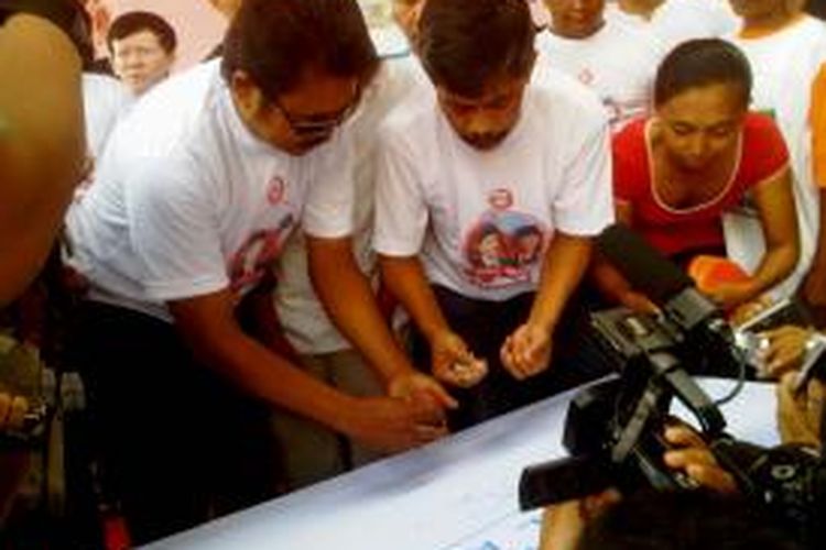Relawan bengkel restorasi Kabupaten Jember, Jawa Timur, membubuhkan cap jempol darah, sebagai bentuk dukungan terhadap pasangan Jokowi- JK, Kamis (12/6/2014).