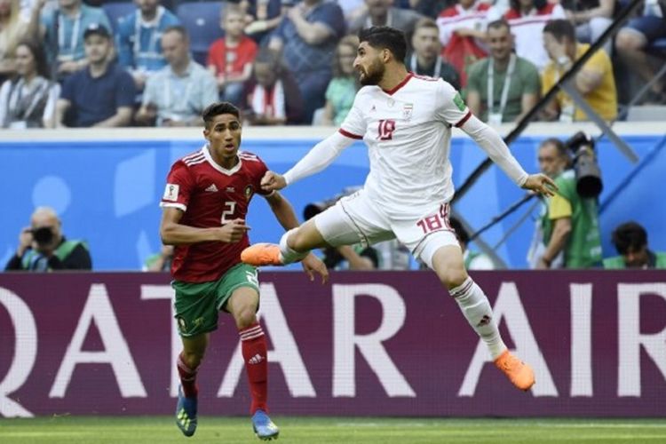 Bek Maroko Achraf Hakimi (merah) berduel dengan penyerang Iran Alireza Jahanbakhsh pada pertandingan Piala Dunia 2018 di Saint Petersburg, 15 Juni 2018. Hakimi merupakan pemain termuda Maroko sepanjang sejarah Piala Dunia. 