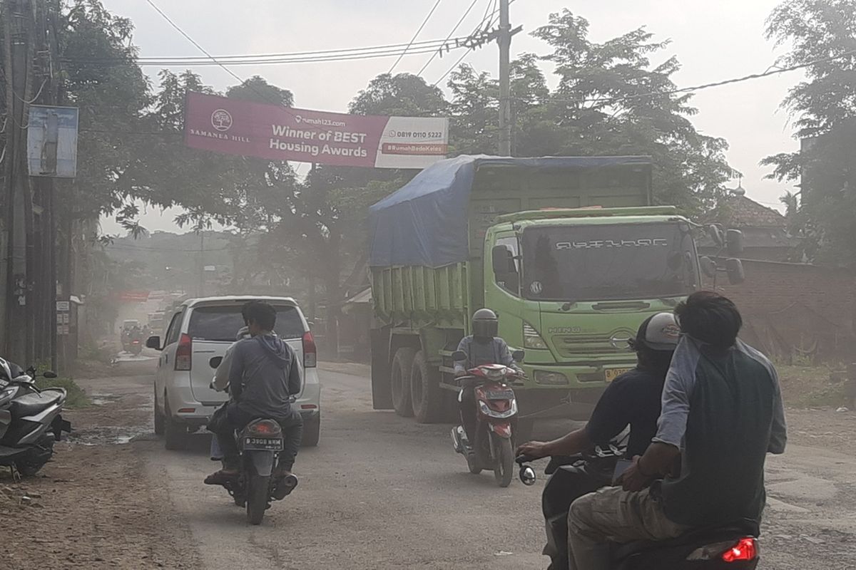 Kondisi jalan rusak dan berdebu akibat truk tambang yang melintas di Jalan Parung Panjang, Kabupaten Bogor, Jawa Barat, Rabu (8/1/2025) siang.
