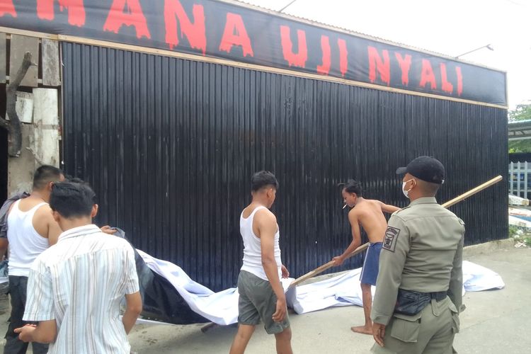 petugas satpol pp padang menurunkan spanduk wahana hiburan