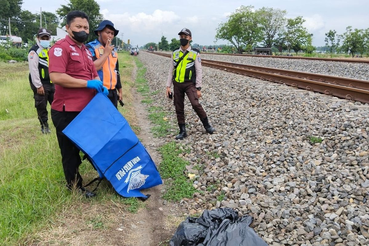Petugas mengevakuasi jasad korban Darno yang tersambar KA di perlintasan tanpa palang pintu di Desa Nglundo, Kecamatan Sukomoro, Kabupaten Nganjuk, Jumat (18/11/2022). Doc: Polres Nganjuk