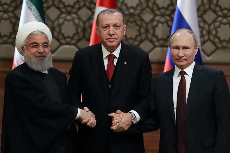 Presiden Iran Hassan Rouhani (kiri), Presiden Turki Recep Tayyip Erdogan (tengah) dan Presiden Rusia Vladimir Putin berjabat tangan usai pertemuan tingkat tinggi membahas krisis Suriah di Ankara, Rabu (4/4/2018).