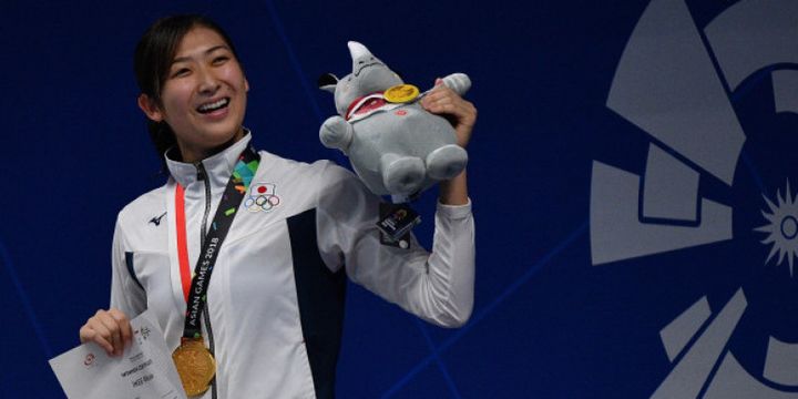 Perenang Jepang Rikako Ikee mengangkatmaskot Asian Games usai upacara penyerahan medali nomor 50 meter Gaya Bebas Putri Asian Games ke-18 Tahun 2018 di Aquatic Centre GBK, Senayan, Jakarta, Jumat (24/8). Rikako Ikee berhasil meraih medali emas sekaligus memecahkan rekor Asian Games dengan catatan waktu 24.53 detik.