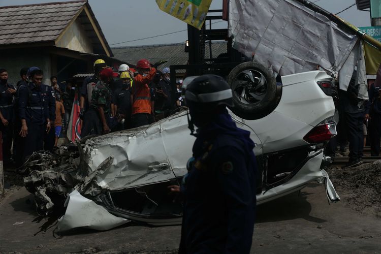 Petugas melakukan evakuasi mobil Mobilio dengan nomor polisi B 1563 NYZ yang tertabrak KRL Commuter Line di Depok, Jawa Barat, Rabu (20/4/2022). Akibat kejadian ini jadwal KRL dari Depok menuju Jakarta terganggu.