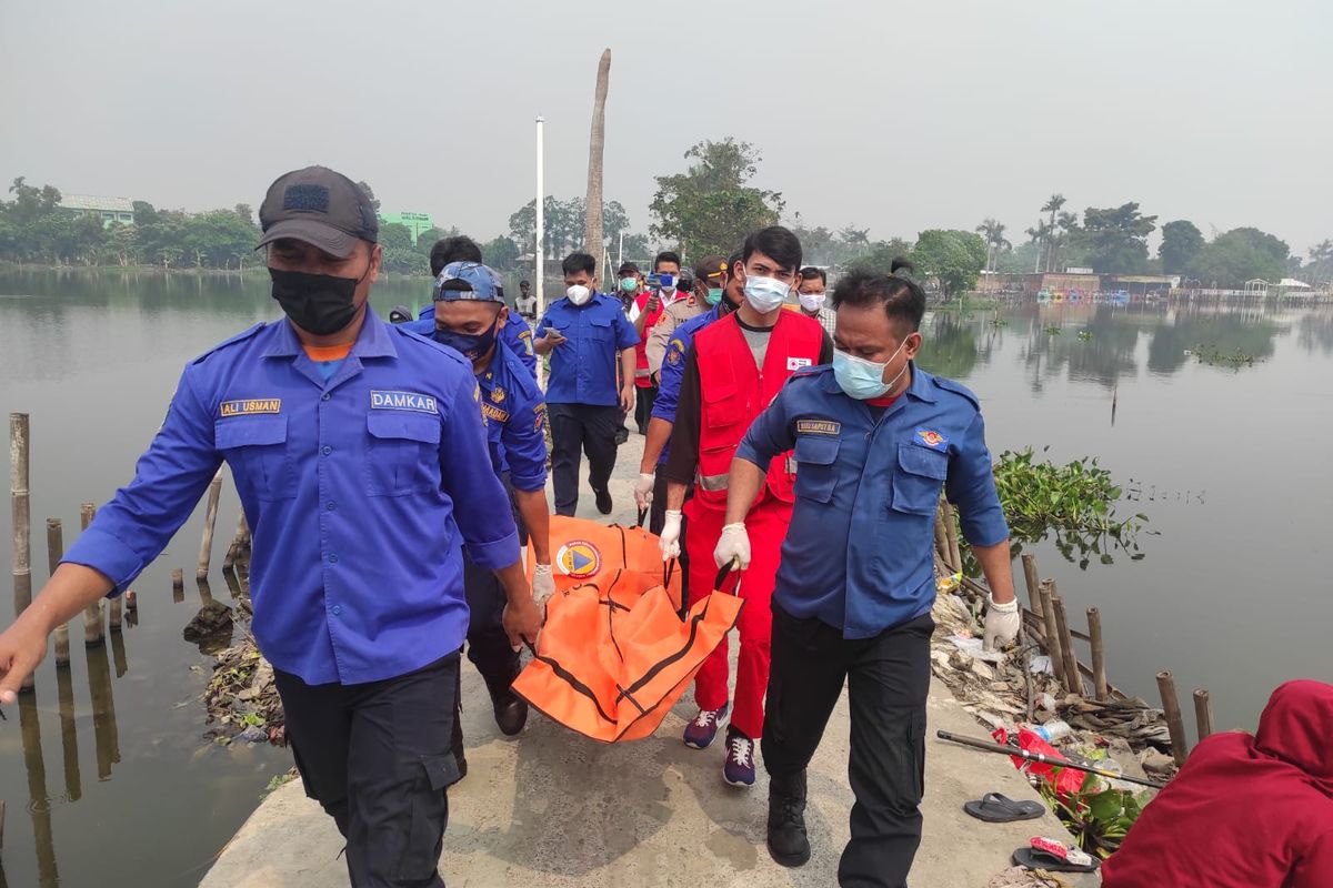 Kepolisian, BPBD, dan PMI, saat sedang mengevakuasi seorang perempuan yang ditemukan tewas di Situ Cipondoh, Kunciran, Pinang, Kota Tangerang, Kamks (15/7/2021).