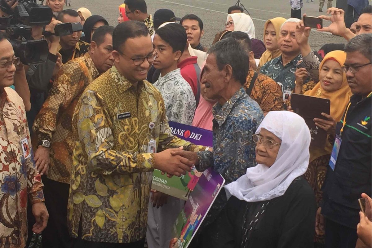 Gubernur DKi Jakarta Anies Baswedan membagikan secara simbolis Kartu Lansia Jakarta kepada sejumlah lansia di Halaman Monumen Nasional (Monas), Kamis (21/12/2017)