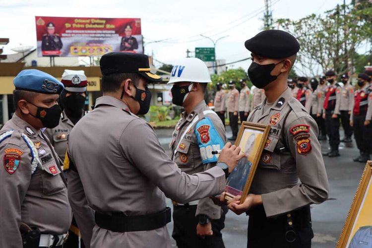 Kepala Polres Sukabumi Kota AKBP Sy Zainal Abidin menuliskan PTDH pada salah satu foto anggota dalam upacara di Sukabumi, Jawa Barat, Selasa (22/3/2022).