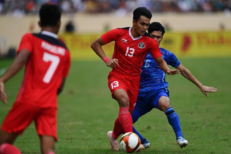Pesepak bola Timnas Indonesia Rachmat Irianto (tengah) berebut bola dengan pesepak bola Timnas Thailand Airfan Doloh (kanan) dalam pertandingan semifinal sepak bola SEA Games 2021 Vietnam di Stadion Thien Truong, Nam Dinh, Vietnam, Kamis (19/5/2022).